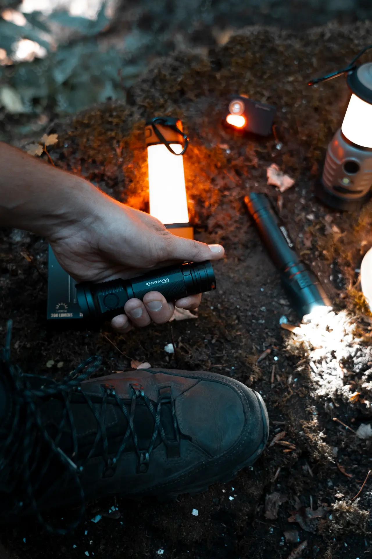 Skywoods DL3000 flashlight held in hand at a campsite